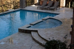 moon shaped spa attached to pool